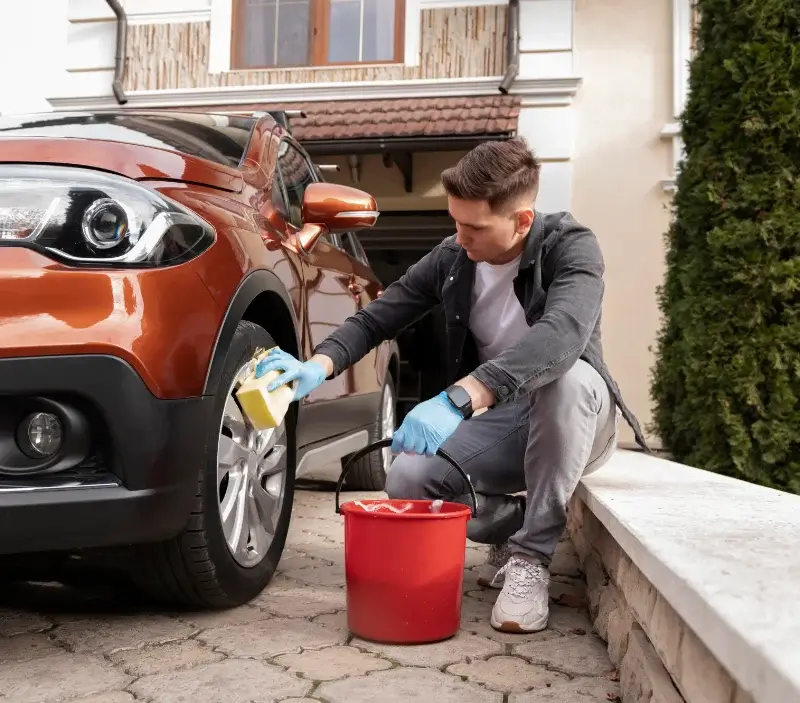 Lavage auto à domicile Neuville-sur-Ain : professionnel intervenant sur un véhicule